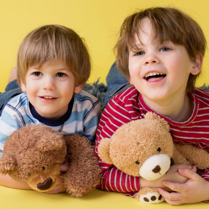 2 friends laughing and holding their teddy bears