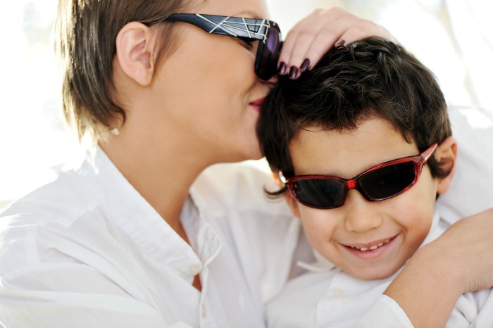 mother kissing son's head - both wearing sunglasses