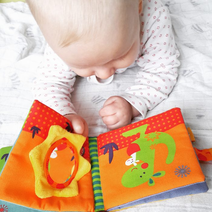 Blond baby reading book