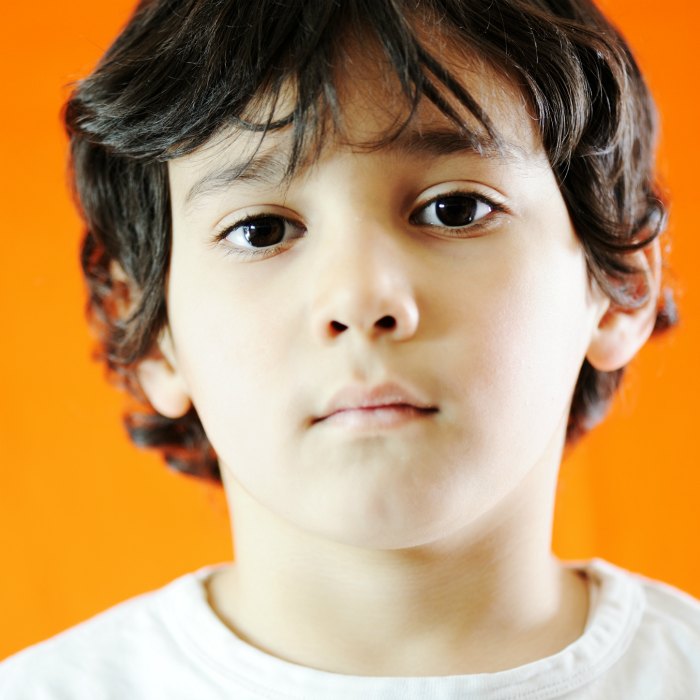 boy looking directly at camera - orange background