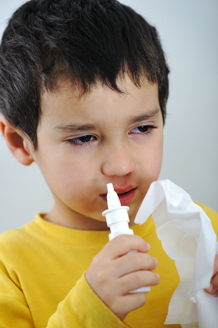 boy with runny nose and nasal spray