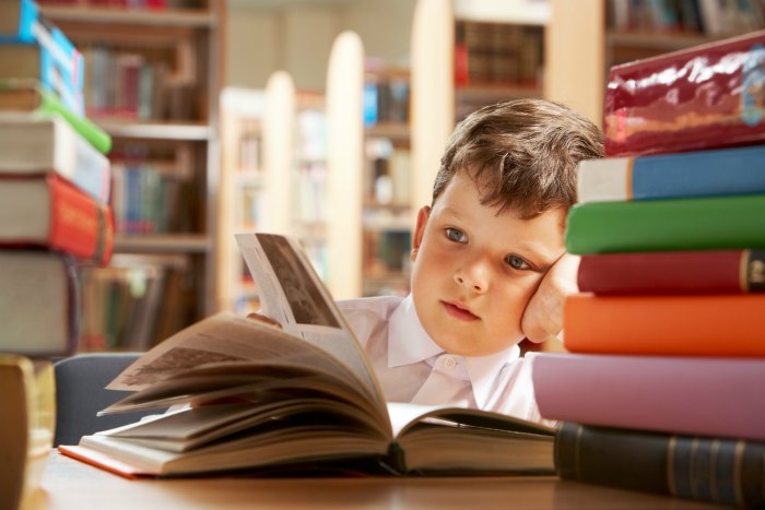 boy looking at book in library