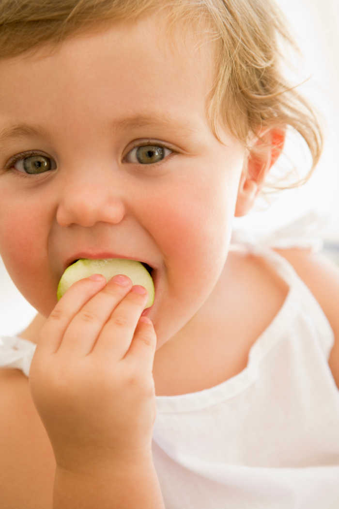 girl eating cucumber slice