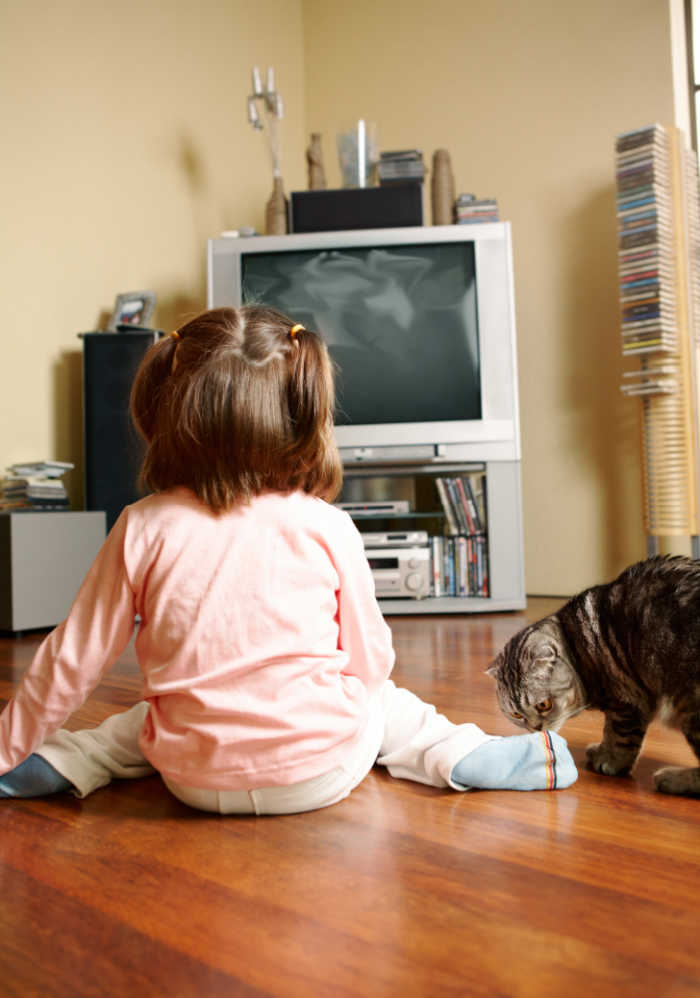 child sitting in a w in front of tv