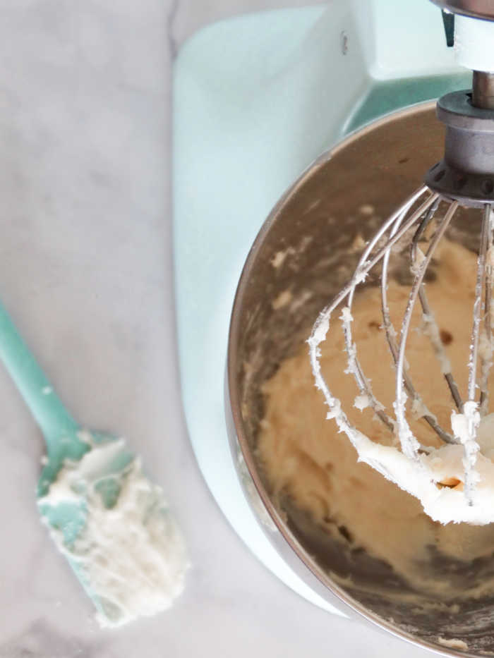 whipped cream in bowl with whisk and sputala