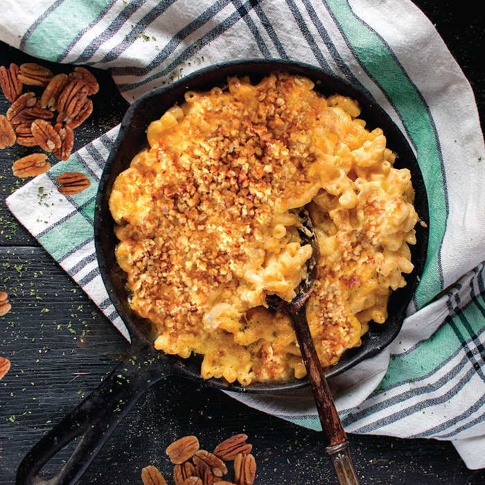 Pecan Mac and Cheese in skillet with pecans and tea towel