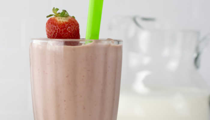 chocolate strawberry smoothie with fresh strawberries and a green straw
