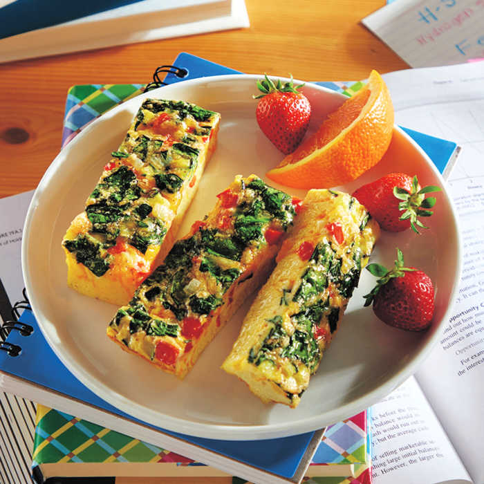 veggie cheese fritatta fingers on a plate with orange slice and strawberries