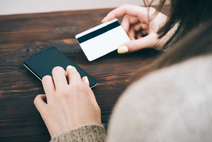 young adult woman holding credit card