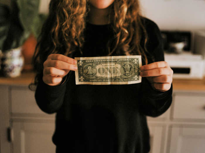 girl holding dollar bill