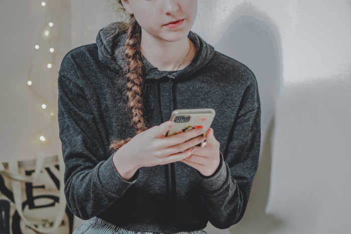 young girl with hair braided on phone