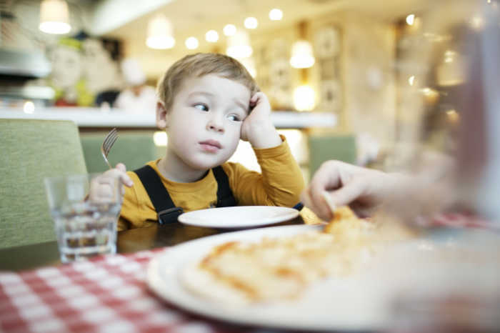 boy looking unhappy at empty plate