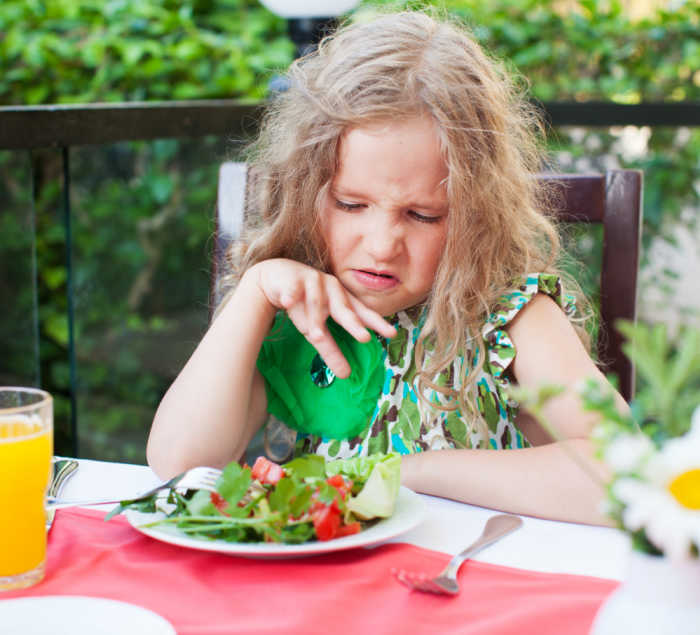 girl looking unhappy at salad - fussy eater