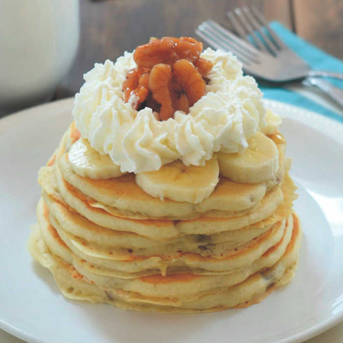 Stack of Walnut Pancakes - topped with sliced bananas and whipped cream