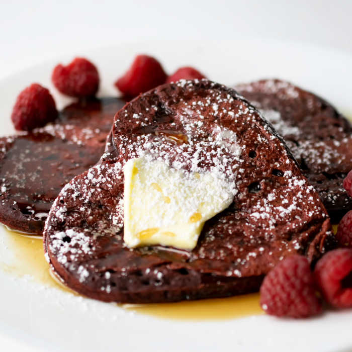 Close up red velvet pancakes with butter and raspberries