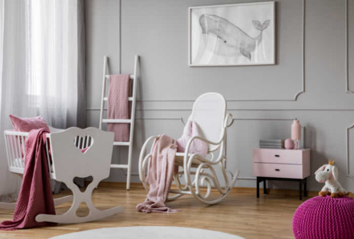 pink theme nursery with white rocking chair