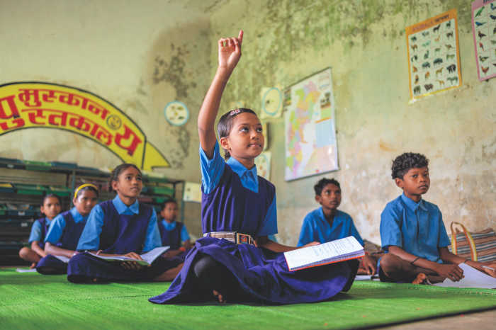 girl raising her hand in class - Empower Girls Globally -  Support Equitable Access to Education 