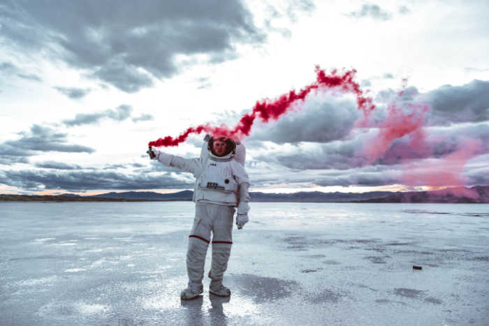 man in astronaut suit with red trailers from emergency signal