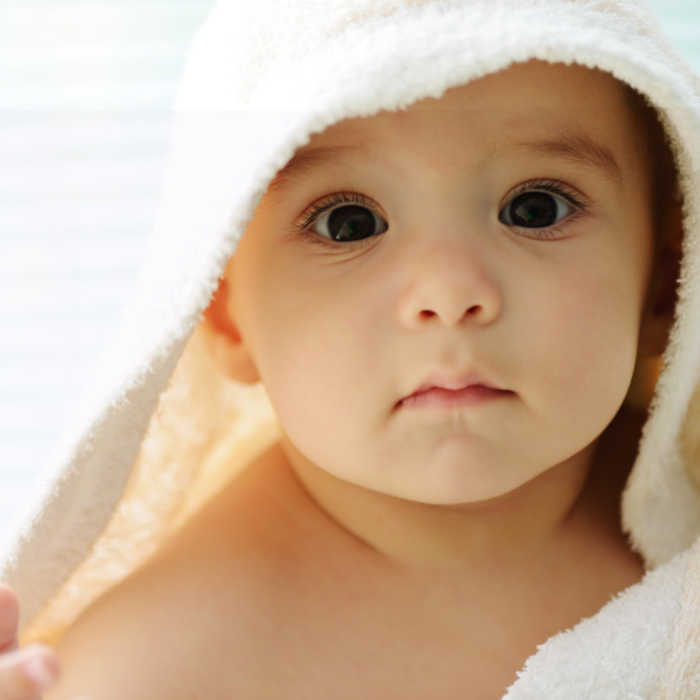 young child snuggled in towel after bath
