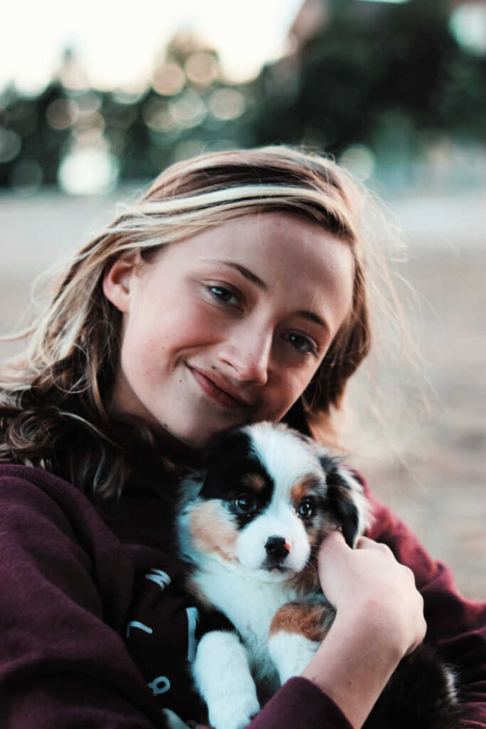 teenage girl hugging aussie puppy dog