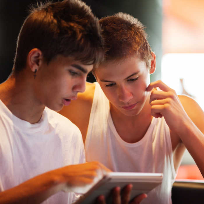 two teenage boys looking at tablet - 5 smart reasons to monitor kids online