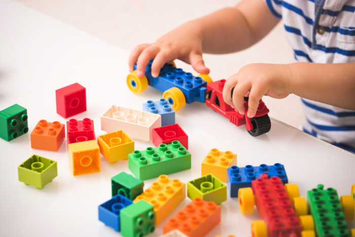 young toddler playing with lego blocks