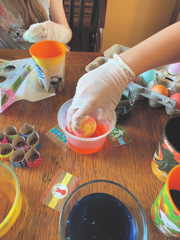 Kids wearing gloves to dye Easter eggs
