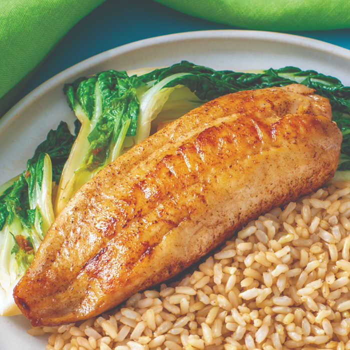 close up of cooked easy white fish recipe on rice with bok choy