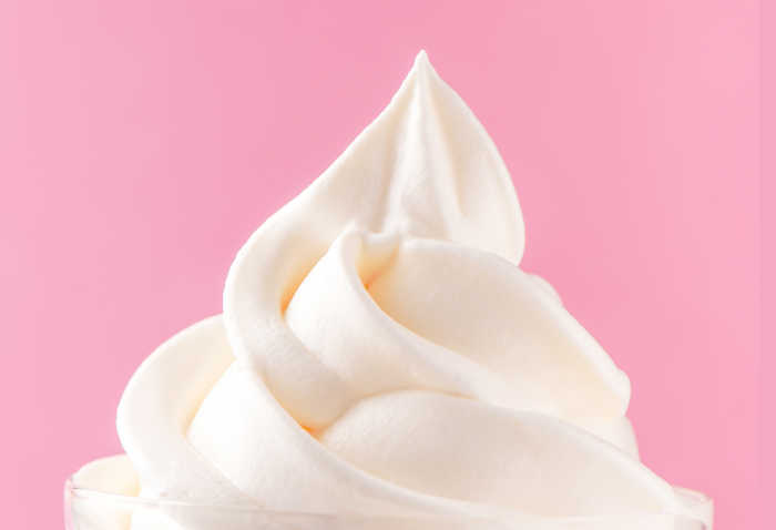 Whipped cream on pink background