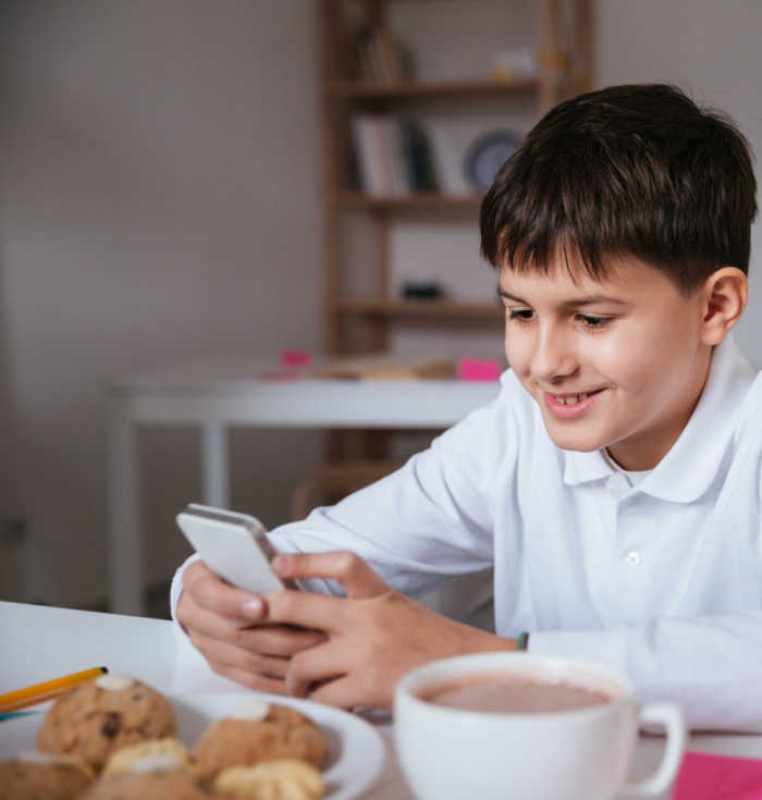 boy sitting at kitchen table on phone
