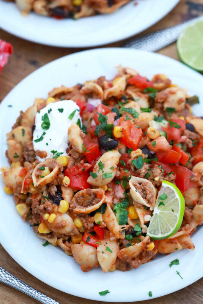 taco pasta served up with sour cream and a slice of lime