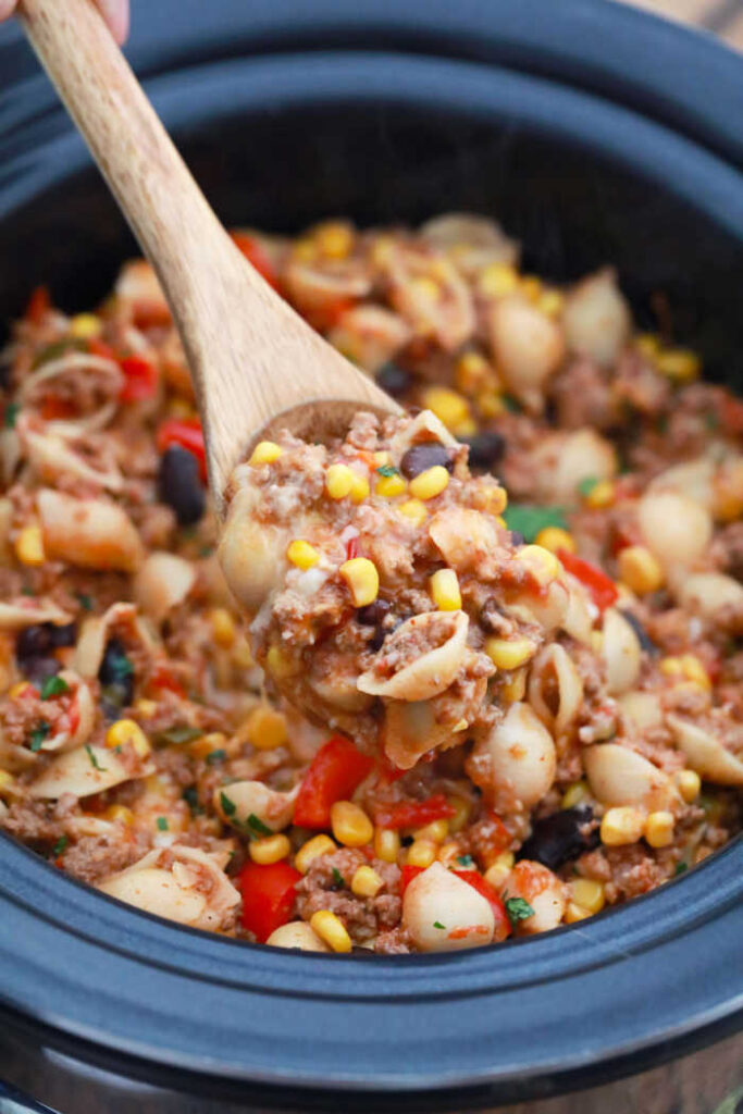 stirring slow cooker taco pasta in the crockpot
