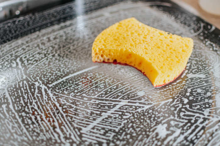 yellow sponge with suds on pan