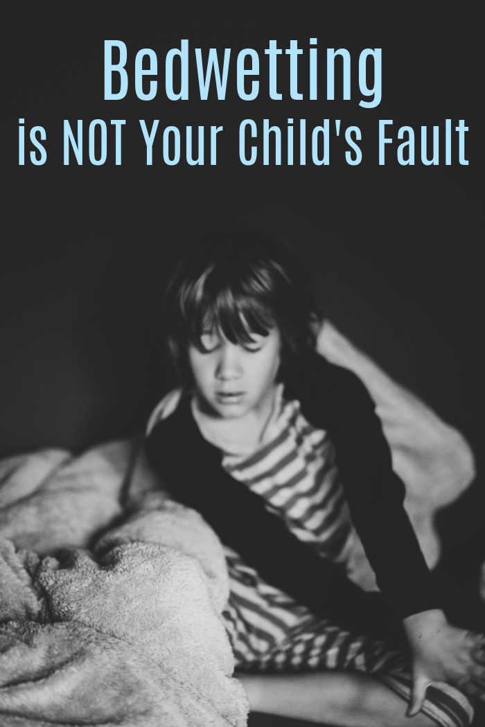 sleepy boy in bed - bedwetting is not your child's fault