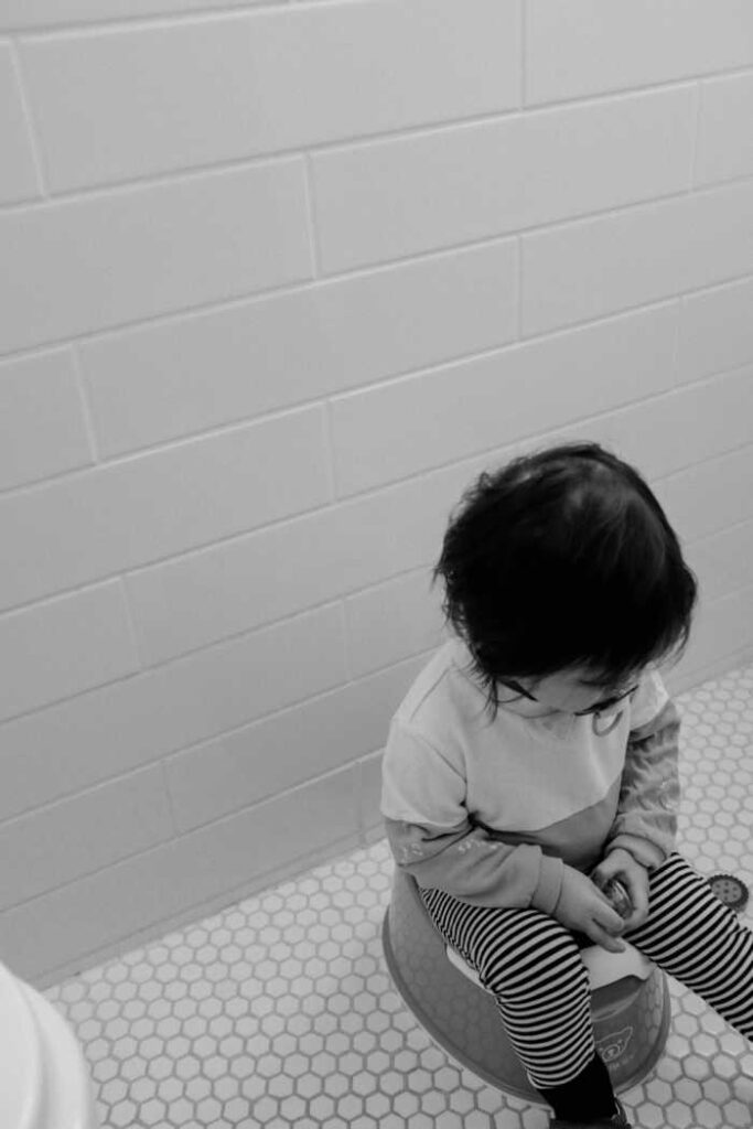 little girl sitting on potty in bathroom
