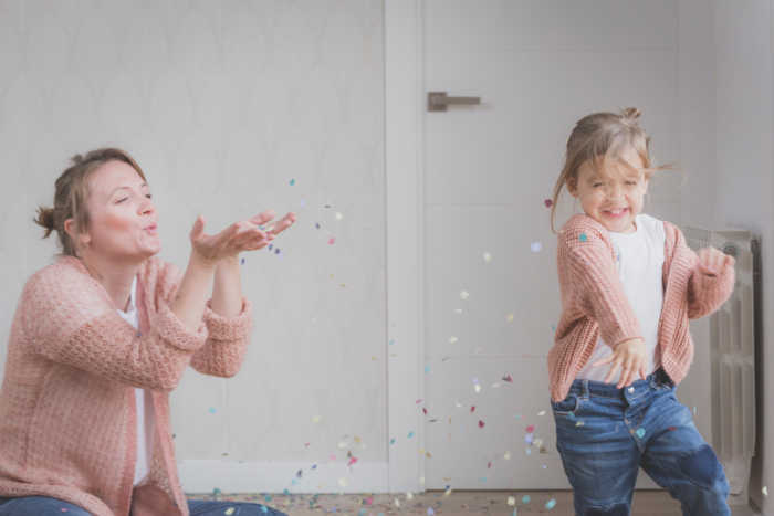 mom and daughter dancing blowing confetti