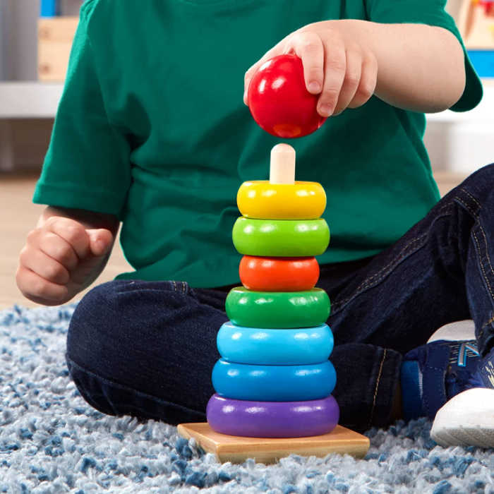 child playing with wooden stacking rings