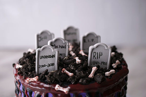 cake topped with candy tombstones and crushed cookies