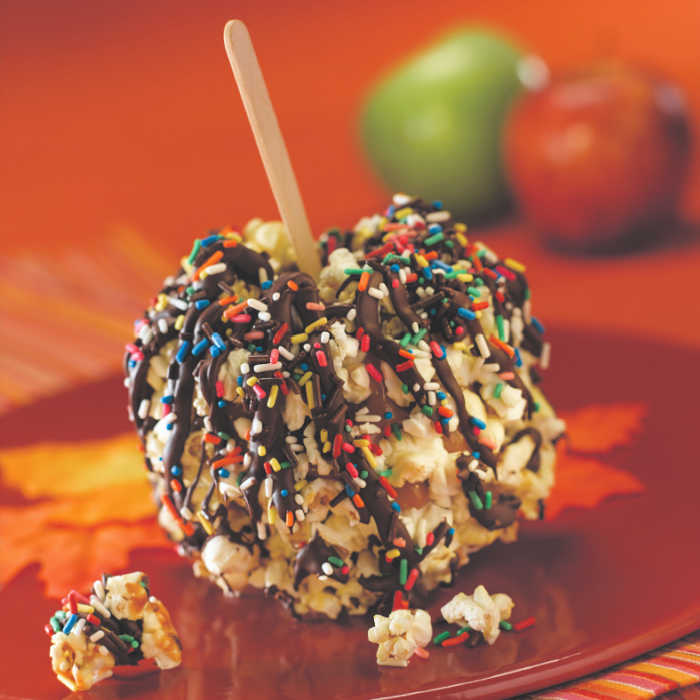 popcorn and caramel covered apple with chocolate drizzle and sprinkles