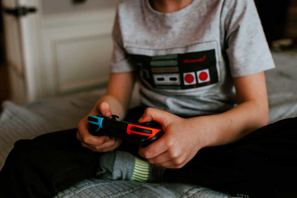 boy playing switch with nintendo game controller on tshirt