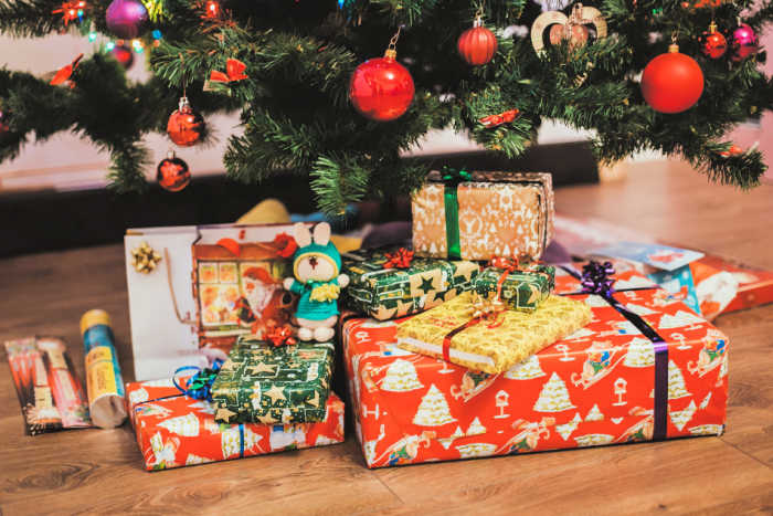 christmas presents wrapped in fun paper under the tree