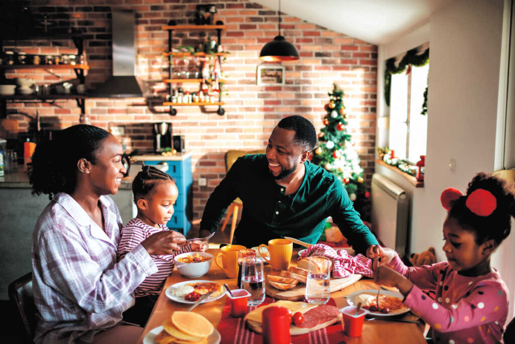 black family at christmas morning breakfast - connect as a family to manage holiday stress