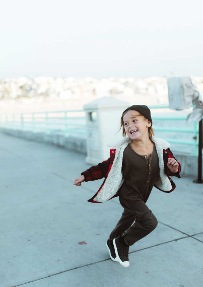boy running laughing on pier