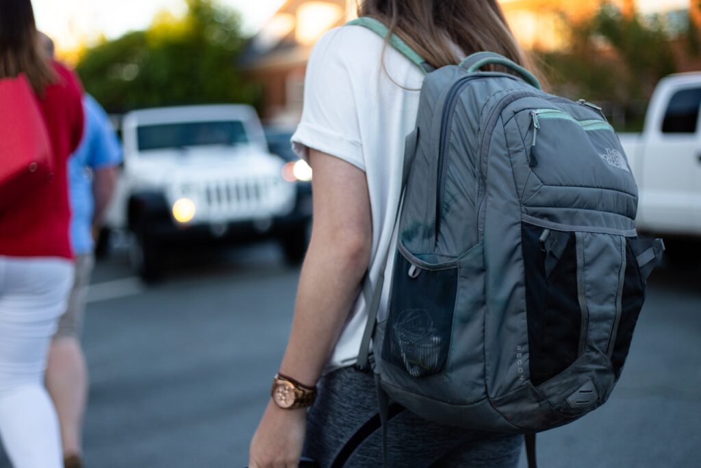 girl walking to school wearing gray backpack