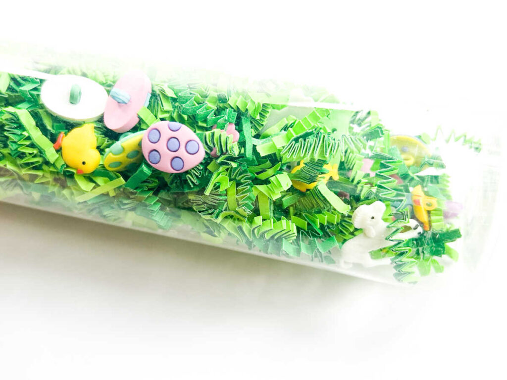 close up showing easter chicks, eggs and lambs in spring sensory bottle
