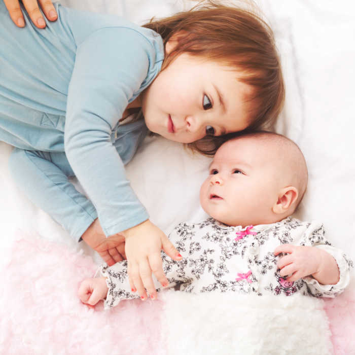 baby sister on mat blanket with infant baby sister
