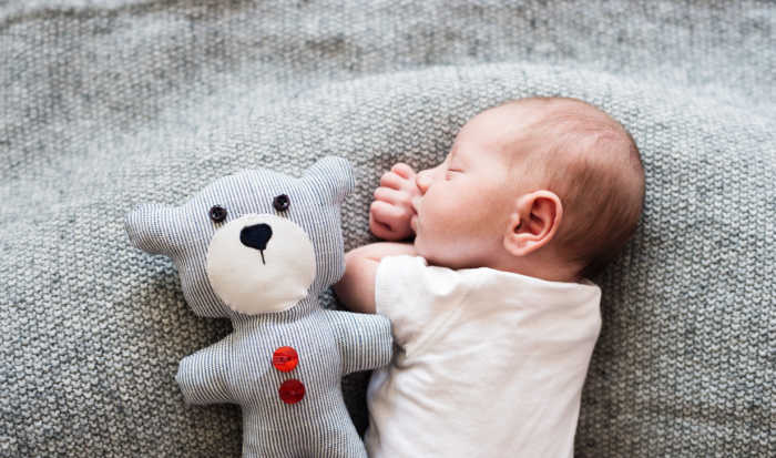 baby on gray blanket with gray teddy bear