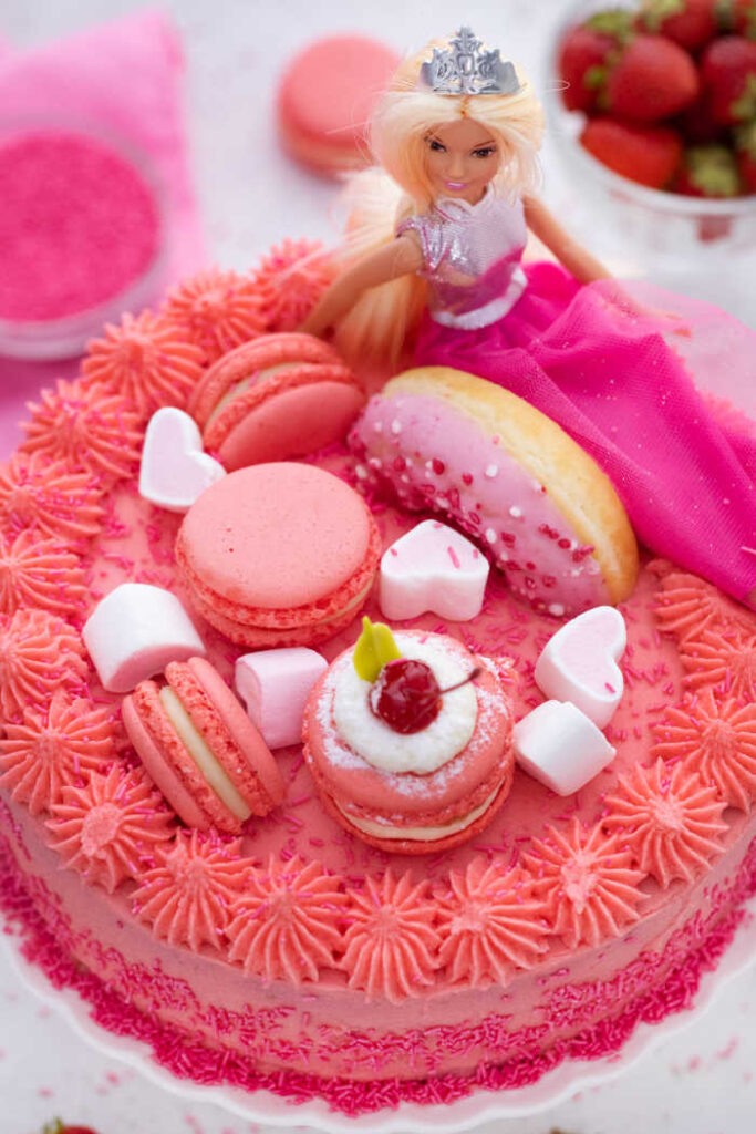 barbie cake topped with barbie doll, macaroon, doughnut, heart marshmallows