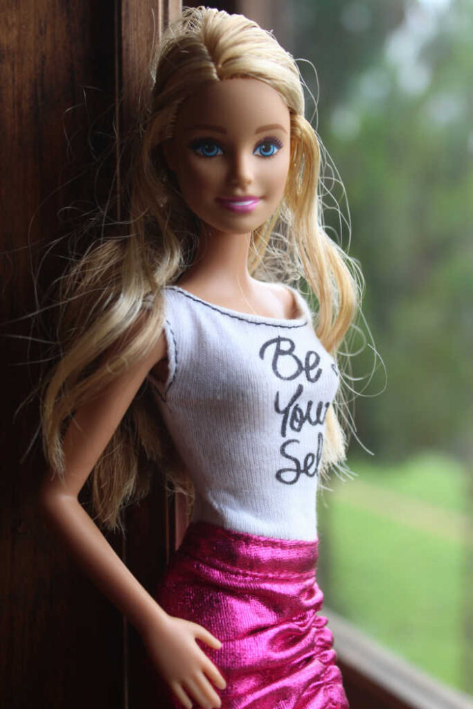 barbie doll posing with be yourself shirt