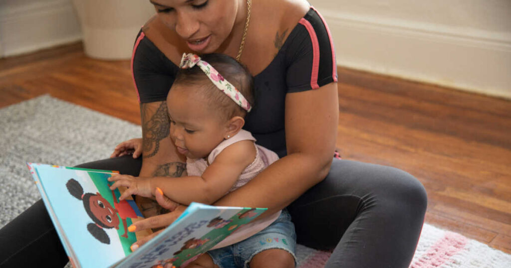 mom reading to her infant daughter